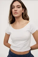 Remera blanca de corte ajustado y largo cropped, con escote redondo amplio y mangas cortas.