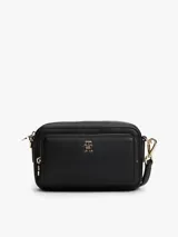 Cartera tipo bandolera de Tommy Hilfiger, color negro con acabado granulado. Presenta cierre de cremallera, bolsillo frontal con cierre, insignia del monograma TH en metal dorado y correa extraíble.