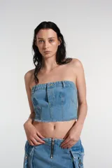 Bustier de denim celeste con cierre lateral y bolsillos decorativos frontales.