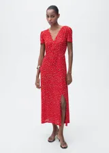 Vestido midi de corte recto con estampado floral, cuello en pico y mangas cortas. Presenta una abertura lateral en la falda y cierre de cremallera lateral.