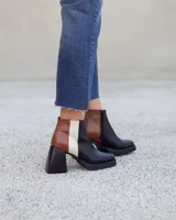 Botinetas de cuero con diseño tricolor en negro, marrón con textura croco y blanco. Presentan taco cuadrado, plataforma y cierre lateral.