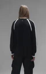 Sweater de punto negro con cuello redondo, mangas largas con franjas laterales blancas y puños en punto rib. Presenta un diseño gráfico bordado en el pecho con la inscripción 'RAVERS' y detalles en blanco.