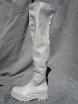 Bota bucanera color beige de cuero sintético, con caña alta, punta redonda y suela track.