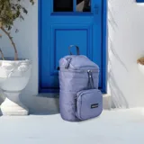 Mochila matera de diseño vertical, color gris azulado, con acabado acolchado y cierres frontales. Cuenta con un compartimento principal espacioso, un bolsillo frontal externo y un asa superior para transporte manual.
