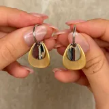 Caravanas de aro con diseño de doble dije en forma de gota, combinando un acabado mate dorado y un acabado brillante plateado.