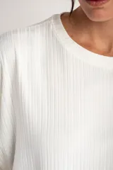 Remera de corte oversize, color blanco, confeccionada en tejido acanalado con mangas cortas y cuello redondo.