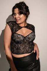 Corset negro con copas y aro, ballenas en la parte delantera, confeccionado en puntilla elastizada y microtul. Detalle de broche en el escote.