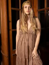 Vestido largo color marrón con bordados florales a tono, escote en V y corte imperio. Tiene falda amplia con volados y breteles finos.