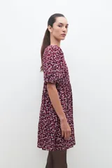 Vestido midi de color bordó con estampado floral blanco, mangas cortas abullonadas y falda con volantes.