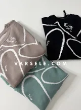 Sweater de tejido de punto con diseño abstracto de líneas blancas sobre fondo de color sólido. Presenta un corte clásico y textura suave.