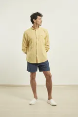 Camisa de cuello mao y manga larga, confeccionada en una mezcla de lino y algodón. Presenta un diseño de corte recto con botones en tono natural y un bolsillo pequeño en el pecho.