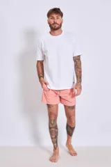 Short de baño liso color salmón con cintura elástica ajustable mediante cordón.