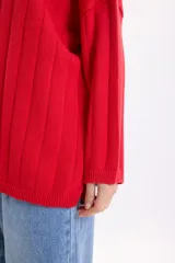 Sweater de punto liso en color rojo, con cuello redondo y diseño holgado de manga larga.