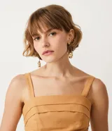 Blusa musculosa corta color ocre, con escote cuadrado, tirantes anchos elásticos, pliegues delanteros y lastex en la espalda.