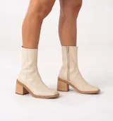 Bota de cuero vacuno color marrón con cierre lateral, taco de madera de 7cm y caña de 19cm.