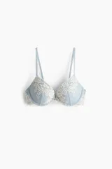 Soutien push-up con aros y copas acolchadas, confeccionado en malla color celeste con aplicaciones de encaje floral en tono crema. Cuenta con breteles ajustables y cierre de corchetes en la espalda.