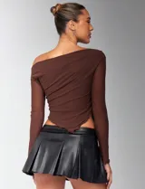 Top marrón con escote off-shoulder, mangas largas transparentes y corte asimétrico.