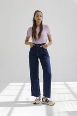 Pantalón de jean azul oscuro, de corte recto y tiro alto, con pinzas en la cintura y cierre frontal.