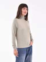 Polera de manga larga en tejido rib color verde grisáceo, de cuello alto y corte ajustado.