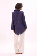 Camisa de lino color azul oscuro, de manga larga y corte holgado, con cuello camisero y cierre frontal de botones.