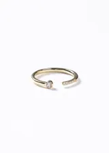 Anillo semi-ajustable de plata 925 con baño de oro 18k, presenta un diseño abierto con un punto de luz de zirconia en un extremo y una hilera de pequeñas zirconias en el otro.