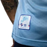 Camiseta de fútbol Umbro del Club Nacional de Football, tercera equipación modelo Away 3. Diseño en color celeste con cuello polo y puños en azul, blanco y rojo. Incluye logo de Umbro, escudo del club y el sponsor Antel en el frente.