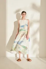 Vestido midi sin mangas de lino, con diseño estampado tipo paisaje en tonos rosado, verde militar y beige, corte recto y falda con volados en la parte inferior.