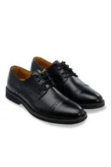 Zapato de vestir tipo oxford color marrón, confeccionado en cuero, con detalles de costura tipo brogue en la puntera y laterales, cordones al tono y suela robusta de goma.