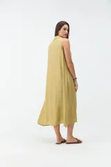 Vestido largo sin mangas de color celeste, con cuello camisero, cierre frontal con botones y bolsillos laterales.