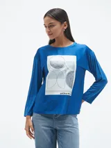 Blusa azul con estampado abstracto en blanco y negro, de mangas largas.