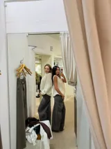 Jean de corte wide leg en color gris, con diseño de cinco bolsillos, cierre frontal con botón y costuras reforzadas.