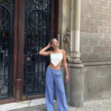 Pantalón palazzo celeste a rayas verticales blancas, de tiro alto y corte holgado.