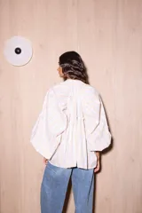 Camisa holgada de algodón con cuello alto y mangas anchas, confeccionada en Italia. Presenta un estampado de rayas verticales finas en tonos beige, blanco, amarillo, rojo y azul.