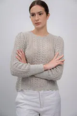 Sweater azul marino de punto calado, confeccionado en 100% baby alpaca, de manga larga y cuello redondo.