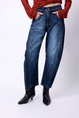 Jean slouch de tiro medio, color azul oscuro, con costuras decorativas en las piernas y diseño de paneles.