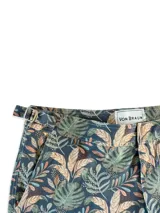 Short de baño con estampado de hojas en tonos verde, marrón y azul sobre fondo azul oscuro.