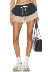 Short deportivo con diseño de doble capa, con capa interior en tono tostado y capa exterior negra con volado en la cintura, además de cordón ajustable blanco.