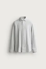 Camisa regular fit de manga larga con diseño de rayas verticales celestes y blancas, cuello italiano y cierre frontal con botones.