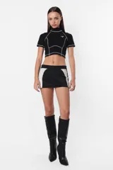 Remera corta color lila con cuello alto, mangas cortas y costuras a la vista.