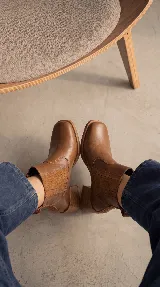 Bota tipo chelsea de cuero negro con paneles elásticos laterales y taco cuadrado de madera de 6 cm.