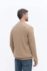 Buzo de tejido acanalado con cuello alto y apertura frontal con cierre, de calce cómodo y estructura limpia.