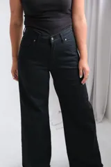 Pantalón de jean negro de corte recto y tiro alto, con cierre frontal de botón y cremallera, y bolsillos laterales.