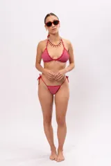 Top de bikini tejido a crochet color rosa con terminaciones en rojo y tirantes finos.