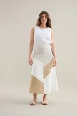 Falda larga de lino con diseño de cortes diagonales en bloques de color blanco, beige y tostado, de corte evasé y caída fluida.