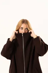 Tapado tipo poncho de color chocolate, confeccionado en tejido de paño, con cierre frontal completo metálico, cuello alto y bolsillos laterales.