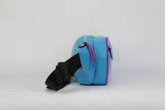 Riñonera de nylon color celeste con detalles en fucsia, cuenta con doble compartimento con cierre y correa negra regulable. Incluye el logo de Miami bordado en el frente.