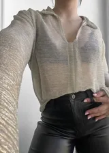 Blusa plateada traslúcida con cuello camisero y mangas largas.