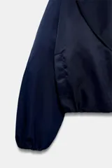 Chaqueta bomber negra ZW Collection con acolchado interior, cuello envolvente de solapa cruzada, mangas largas con puños elásticos y bajo con elástico.