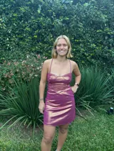 Vestido negro de fiesta, corte mini, con top tipo corsé con costuras fruncidas y breteles finos que se atan en la espalda. Elástico en la cintura trasera.