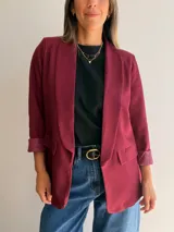 Blazer sastrero de corte clásico con solapas frontales y bolsillos con solapa. Presenta mangas largas con puños vueltos y un diseño forrado que ofrece una caída estructurada y elegante.